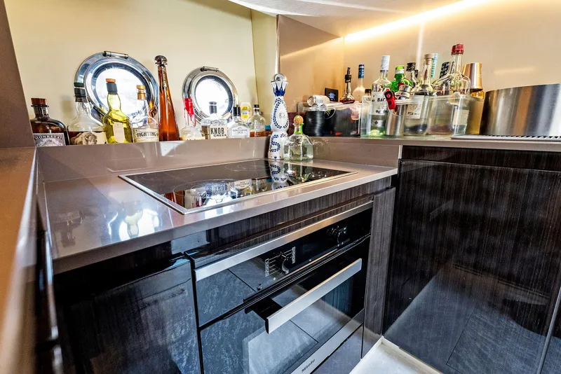 Slide: The Image of Luxurious kitchen area on a 2019 Azimut 77S yacht with modern appliances and bar setup. - 28