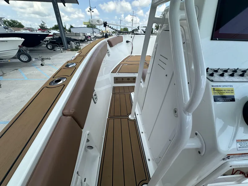 Slide: The Image of Interior view of a 2019 Clearwater 2300 boat with brown seating and wood-like flooring. - 18