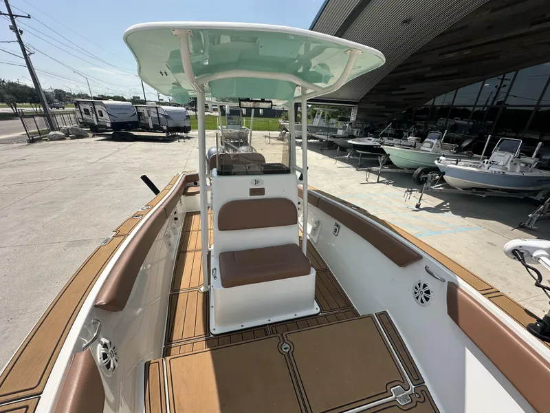 Slide: The Image of 2019 Clearwater 2300 boat with tan seating and deck, displayed at a dealership. - 9