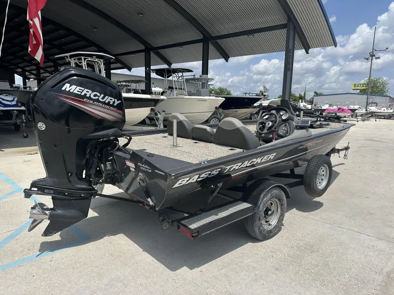Slide: The Image of 2015 Tracker Pro Team 190 TX bass boat with Mercury outboard motor in a marina. - 8