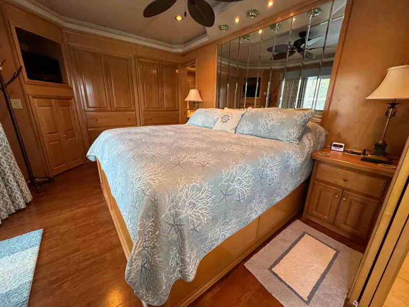 Slide: The Image of Cozy bedroom in a 2005 Fantasy Houseboat 19x90 with wood paneling and floral bedding. - 40
