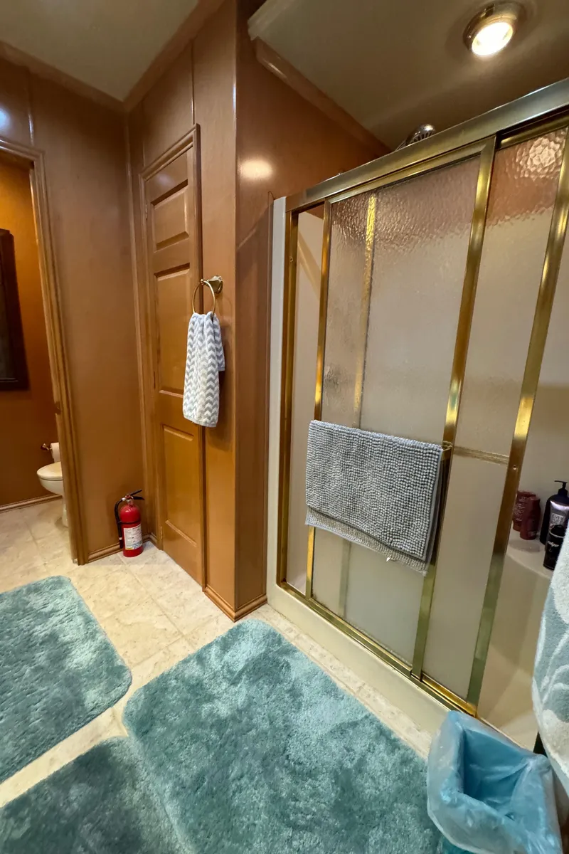 Slide: The Image of Bathroom interior of a 2005 Fantasy Houseboat 19x90 with wooden cabinets and a sink. - 47