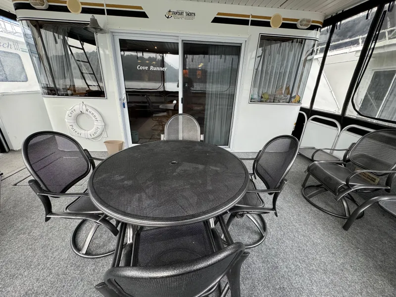 Slide: The Image of 2005 Fantasy Houseboat 19x90 outdoor seating area with round table and chairs. - 5