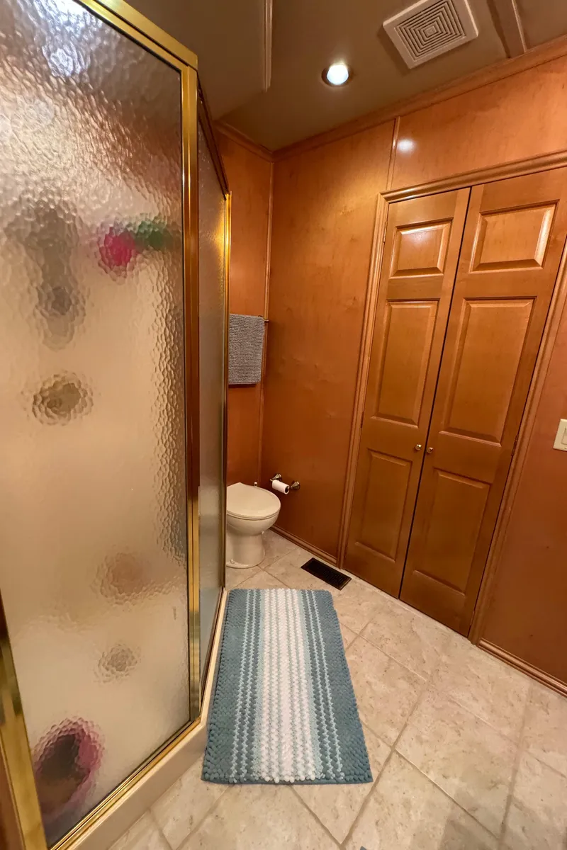 Slide: The Image of Houseboat bathroom with shower, toilet, and wooden cabinets, Fantasy Houseboat 19x90, 2005. - 55