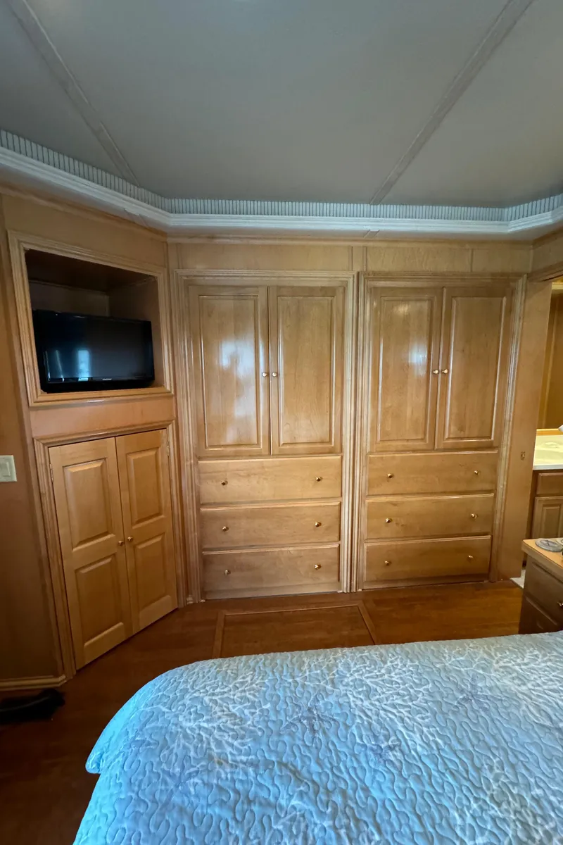 Slide: The Image of Bedroom interior of 2005 Fantasy Houseboat 19x90 with wooden cabinets and TV. - 56