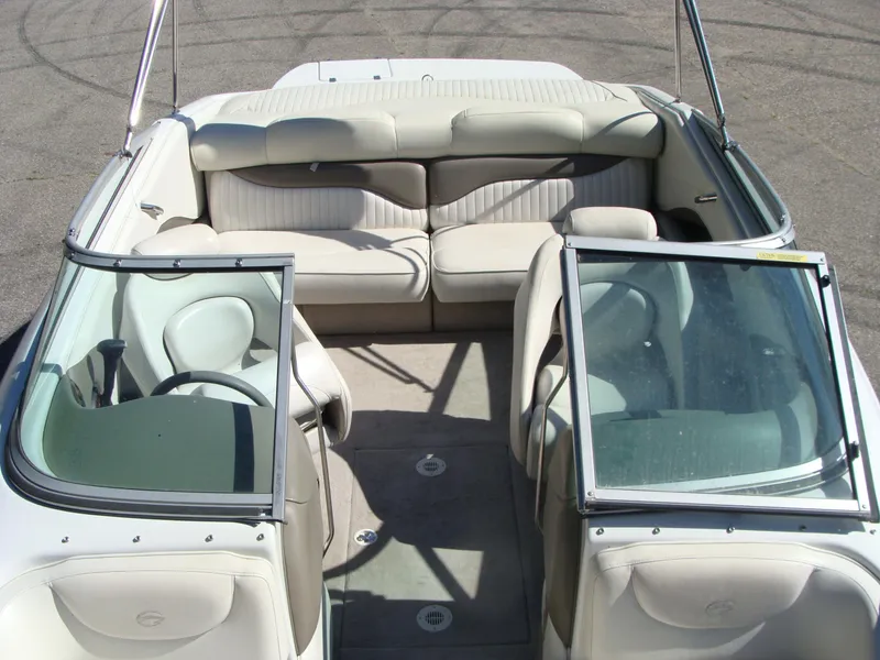 Slide: The Image of 2005 Crownline Bowrider 202 BR interior with beige seating and open windshield. - 12