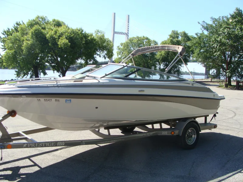 Slide: The Image of 2005 Crownline Bowrider 202 BR on trailer near river and bridge. - 9