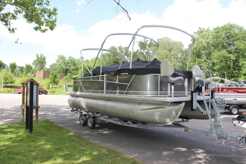 Slide: The Image of 2021 SunChaser Geneva Cruise 24 SB pontoon boat on a trailer in a park. - 2