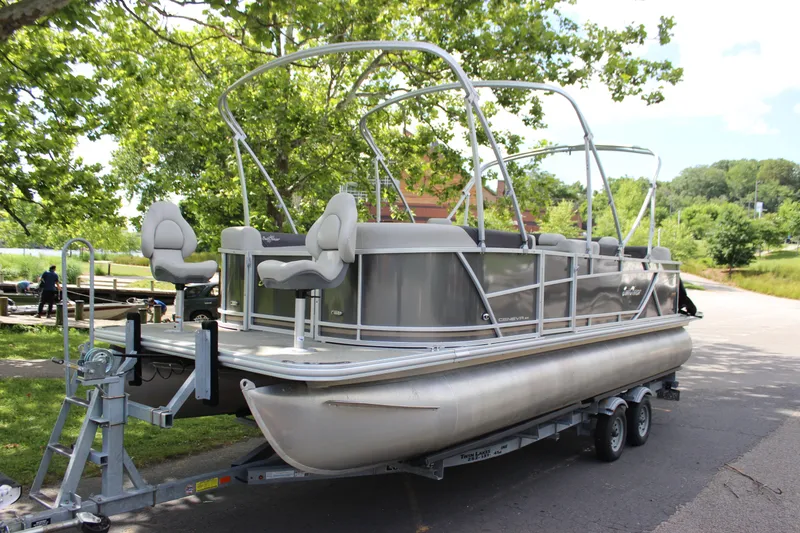 Slide: The Image of 2021 SunChaser Geneva Cruise 24 SB pontoon boat on a trailer in a park setting. - 27