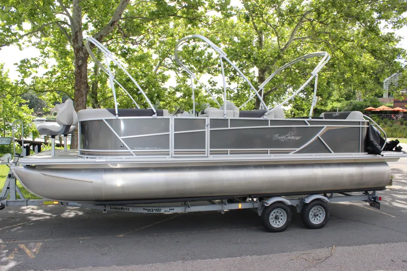 Slide: The Image of 2021 SunChaser Geneva Cruise 24 SB pontoon boat on a trailer, parked under trees. - 31