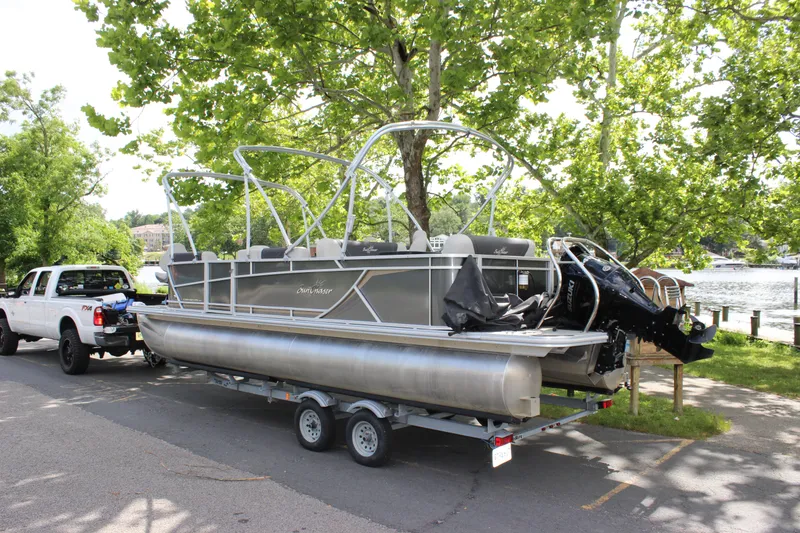 Slide: The Image of 2021 SunChaser Geneva Cruise 24 SB pontoon boat on trailer, towed by a white truck near a lake. - 35