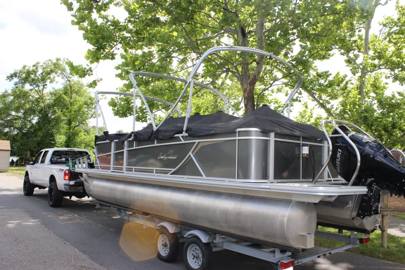 Slide: The Image of 2021 SunChaser Geneva Cruise 24 SB pontoon boat on trailer, towed by a white truck. - 37