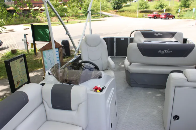 Slide: The Image of 2021 SunChaser Geneva Cruise 24 SB pontoon boat interior with plush seating and steering console. - 5