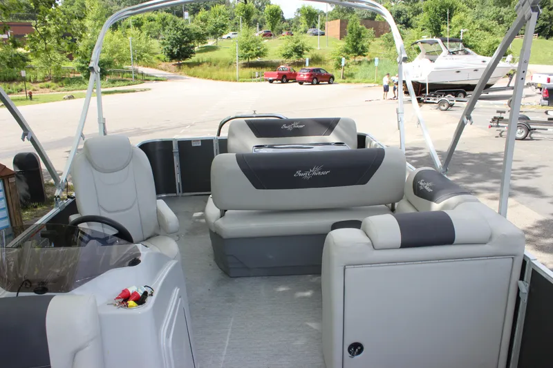 Slide: The Image of 2021 SunChaser Geneva Cruise 24 SB pontoon boat interior with plush seating and steering console. - 6