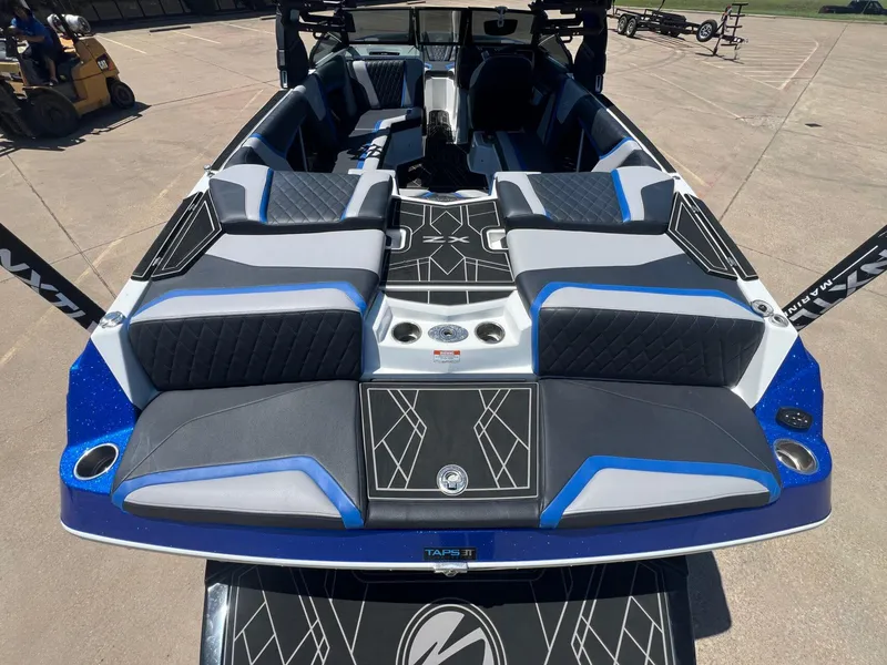 Slide: The Image of 2023 Tigé 25ZX boat interior with blue and gray seating, viewed from the rear. - 7
