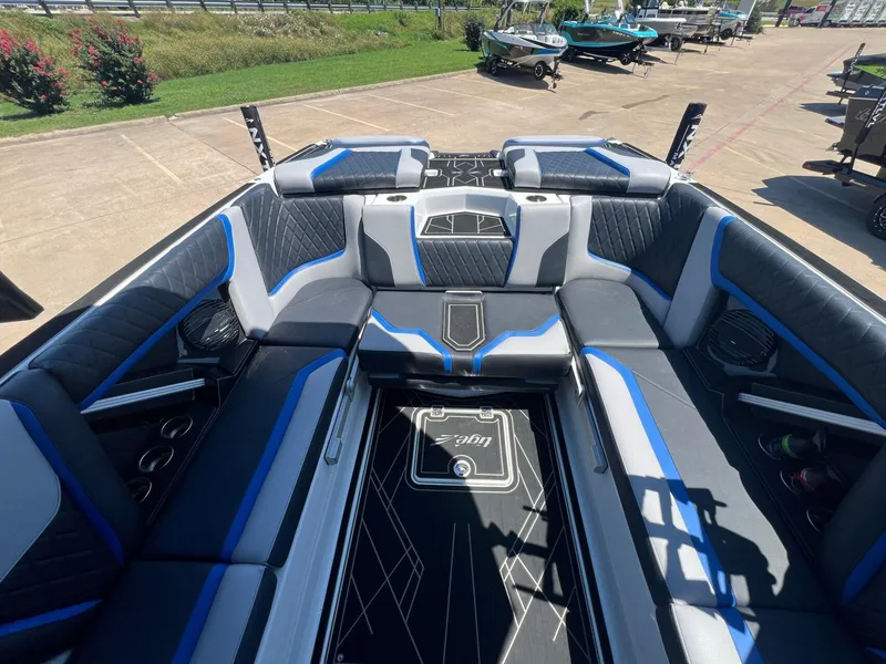 Slide: The Image of 2023 Tigé 25ZX boat interior with blue and gray seating, docked outdoors. - 9