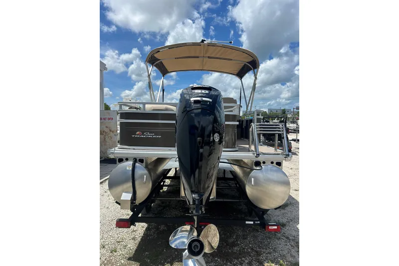 Slide: The Image of 2024 Sun Tracker SportFish 20 DLX pontoon boat with outboard motor, parked outdoors. - 4