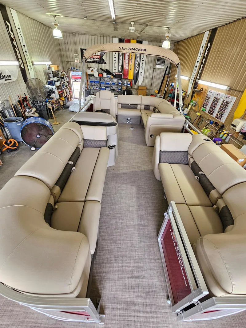 Slide: The Image of 2024 Sun Tracker Party Barge 20 DLX pontoon boat interior in a garage. - 2