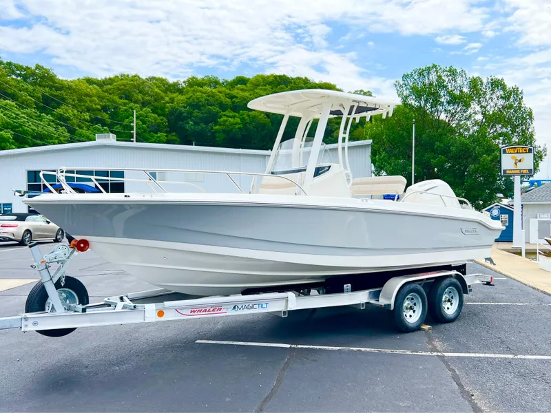 Slide: The Image of 2024 Boston Whaler 220 Dauntless boat on a trailer in a parking lot. - 12