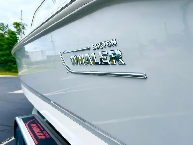 Slide: The Image of 2024 Boston Whaler 220 Dauntless boat side view with logo. - 13