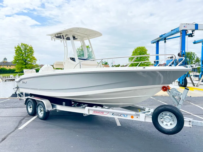 Slide: The Image of 2024 Boston Whaler 220 Dauntless boat on a trailer at a marina. - 14