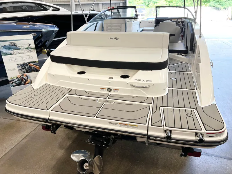 Slide: The Image of 2024 Sea Ray SPX 210 boat with spacious deck and modern design in showroom. - 8