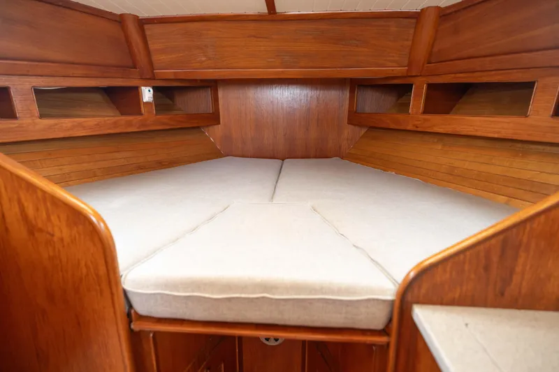 Slide: The Image of 1990 Little Harbor 34 Express Direct Drive cabin interior with wooden finish and cushioned bed. - 9