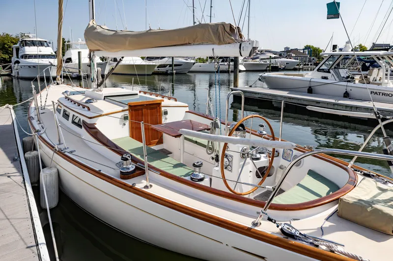 Slide: The Image of 2005 Morris M36 sailboat docked at marina, showcasing elegant wooden details and spacious deck. - 12
