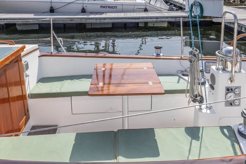 Slide: The Image of Cockpit of a 2005 Morris M36 sailboat with wooden table and green cushions. - 13