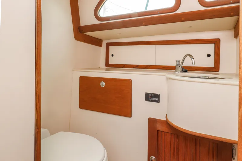 Slide: The Image of Compact bathroom in a 2005 Morris M36 boat with wooden accents and a small sink. - 18