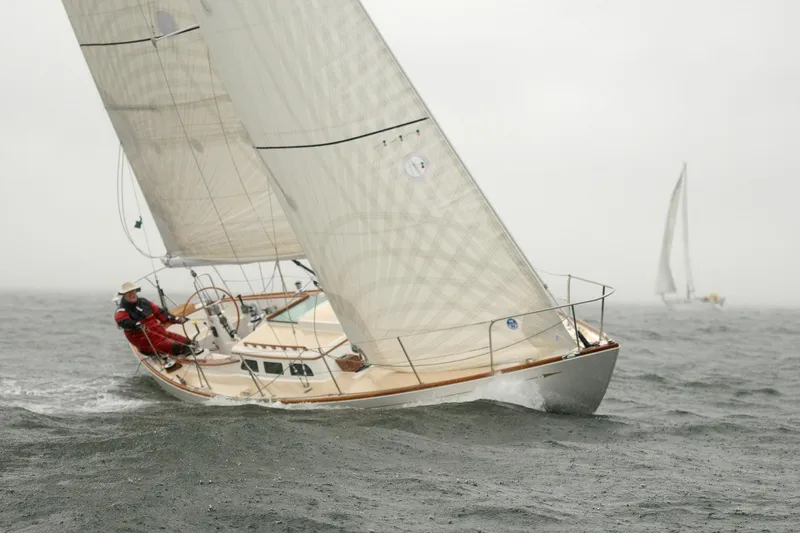 Slide: The Image of 2005 Morris M36 sailboat navigating through misty waters. - 2