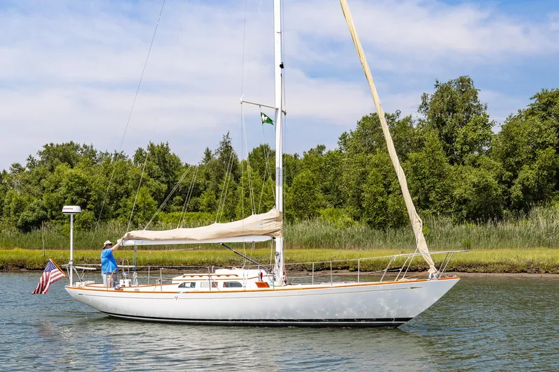 Slide: The Image of 2005 Morris M36 sailboat on calm water with lush green background. - 23