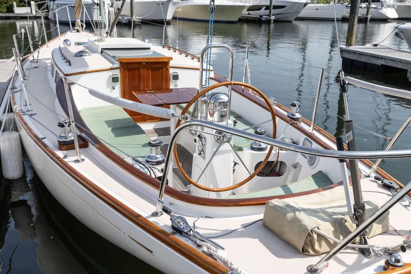 Slide: The Image of 2005 Morris M36 sailboat docked at marina, showcasing elegant wooden details and polished deck. - 4