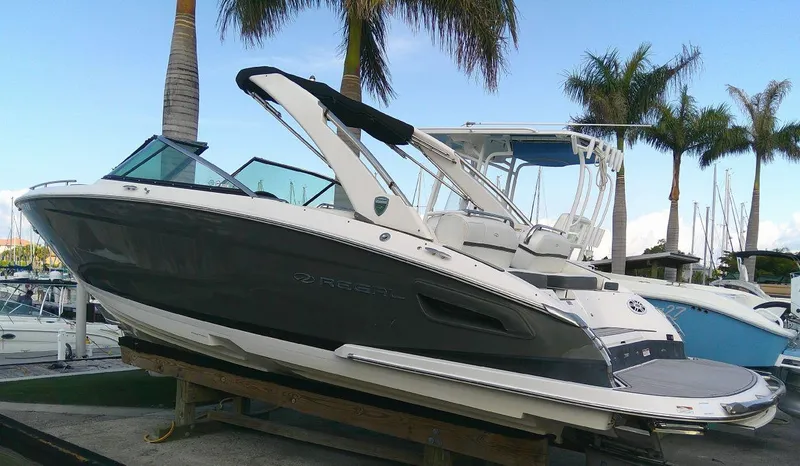 Slide: The Image of 2017 Regal 2800 Bowrider boat docked with palm trees in the background. - 1