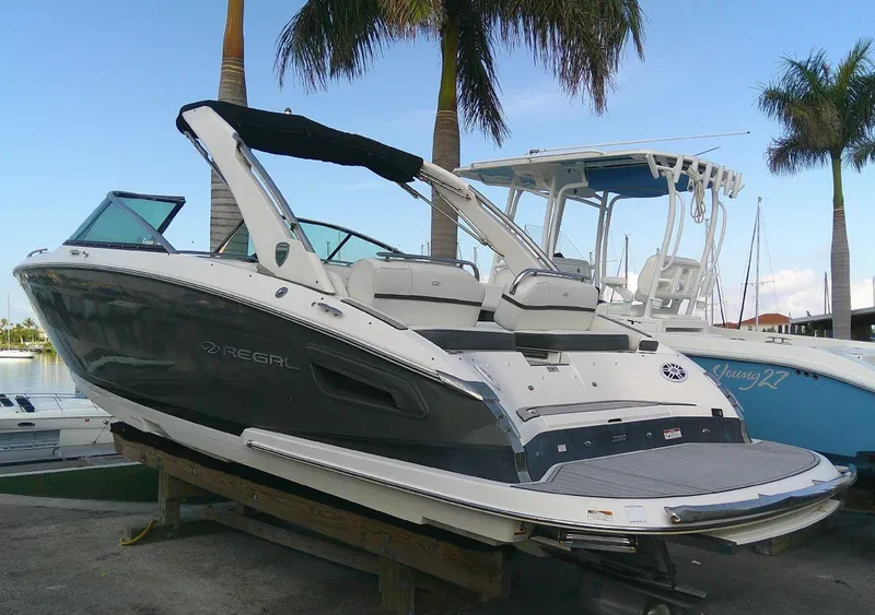 Slide: The Image of 2017 Regal 2800 Bowrider boat on display near palm trees. - 2