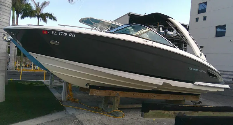 Slide: The Image of 2017 Regal 2800 Bowrider boat on a lift, docked near palm trees. - 3