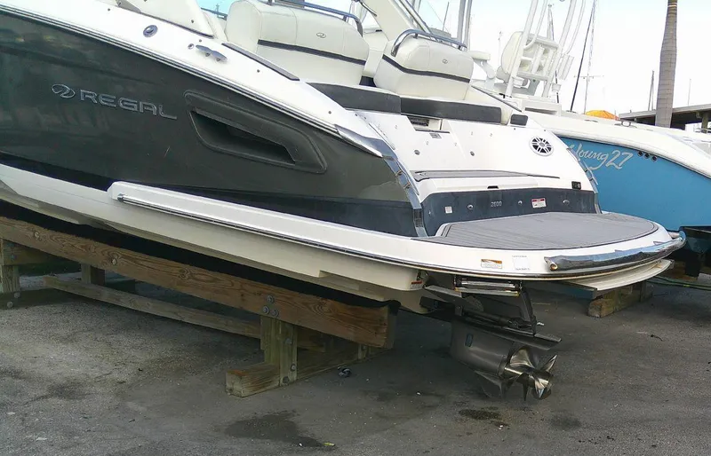 Slide: The Image of 2017 Regal 2800 Bowrider boat on wooden supports in a marina. - 31