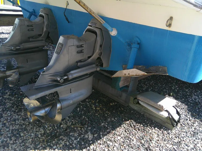 Slide: The Image of 2005 Larson Cabrio 330 boat stern drives and propellers on gravel. - 12