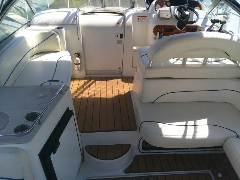 Slide: The Image of 2005 Larson Cabrio 330 boat interior with white seating and wooden flooring. - 13