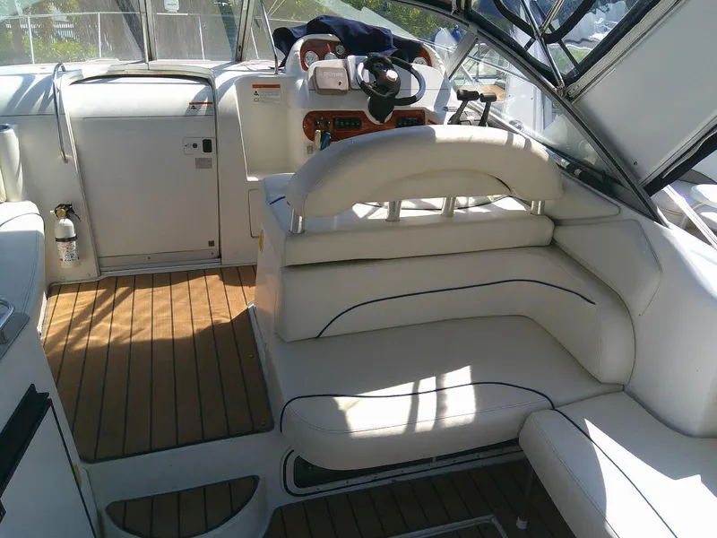 Slide: The Image of 2005 Larson Cabrio 330 boat interior with white seating and wooden flooring. - 14