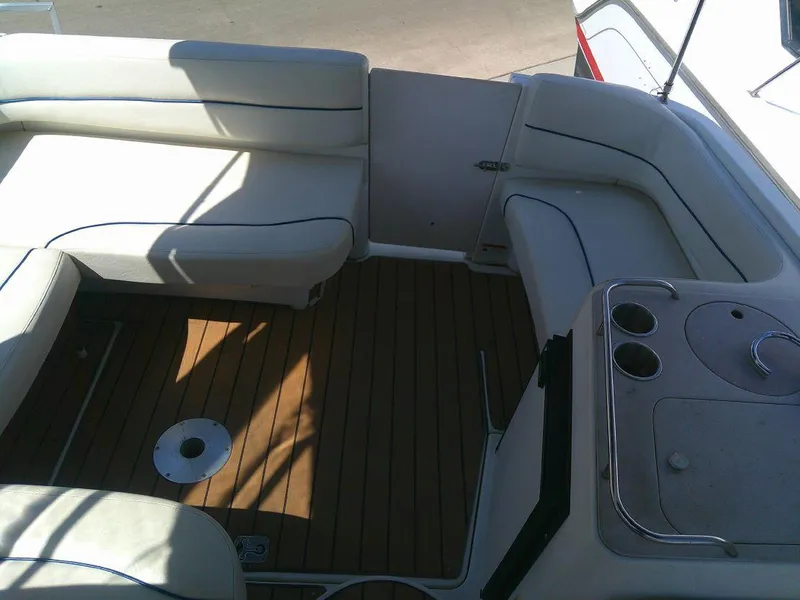 Slide: The Image of 2005 Larson Cabrio 330 boat interior with white seating and wooden floor. - 16