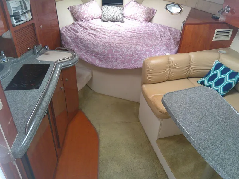Slide: The Image of 2005 Larson Cabrio 330 interior with bed, kitchenette, and seating area. - 18
