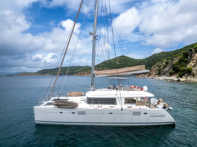 Slide: The Image of Lagoon 560 catamaran sailing near lush coastline under a partly cloudy sky, 2012 model. - 11