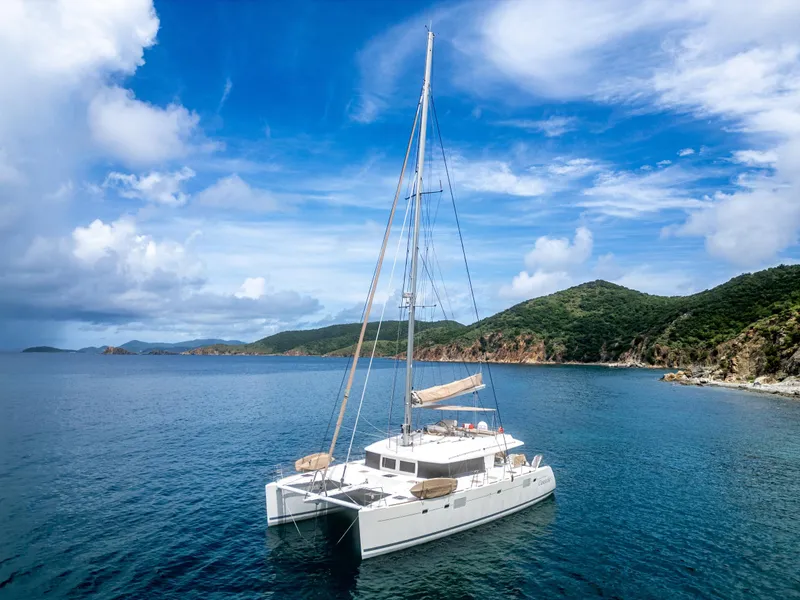 Slide: The Image of Lagoon 560 catamaran sailing in serene blue waters near lush green islands, 2012 model. - 18