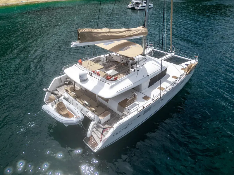 Slide: The Image of Lagoon 560 catamaran, 2012 model, anchored in clear blue water, aerial view. - 2