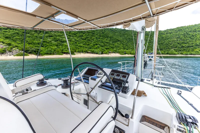 Slide: The Image of Luxurious 2012 Lagoon 560 yacht cockpit with scenic ocean and lush green island view. - 23