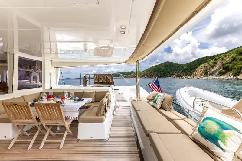 Slide: The Image of Luxurious 2012 Lagoon 560 yacht deck with dining area, scenic ocean view, and comfortable seating. - 36