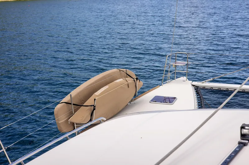 Slide: The Image of Lagoon 560 yacht deck with dinghy, 2012 model, on calm blue water. - 45