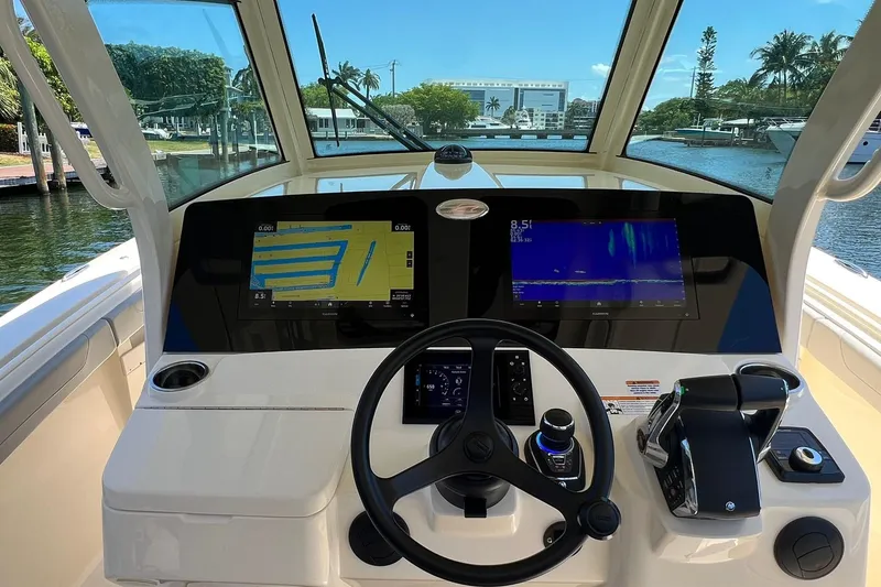 Slide: The Image of 2024 Scout 355 LXF boat helm with dual navigation screens and steering wheel. - 11