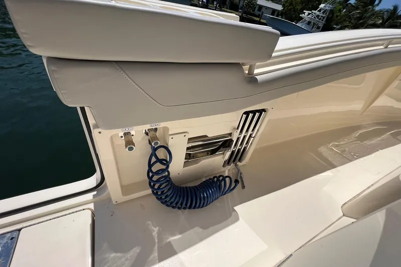 Slide: The Image of 2024 Scout 355 LXF boat deck with coiled hose and storage compartment. - 13